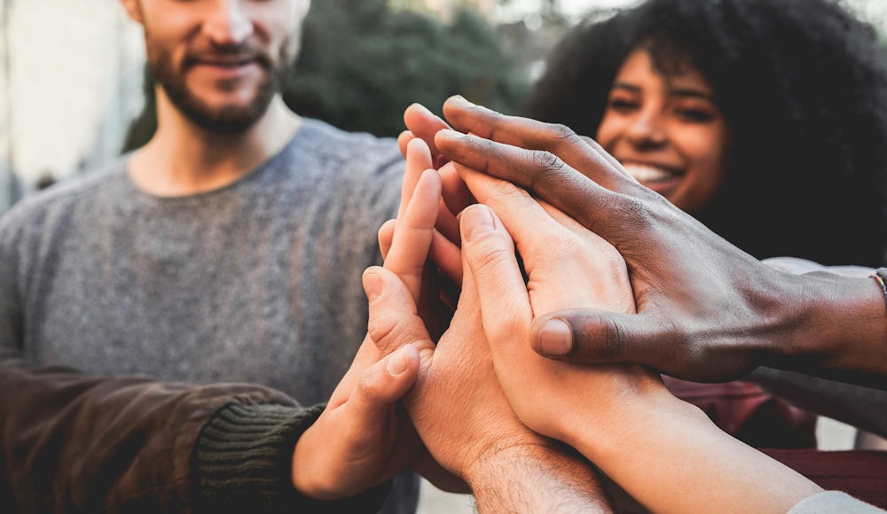Close shot of hands clustered together in the middle of an addiction treatment group.