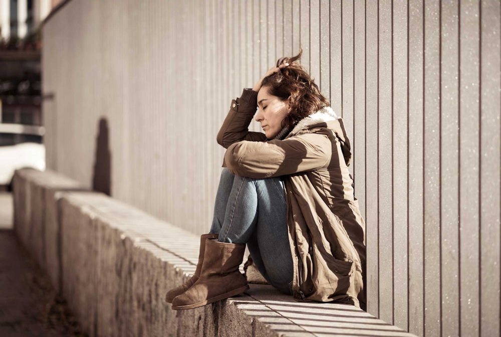 woman with addiction sits on wall reflecting on cocaine use
